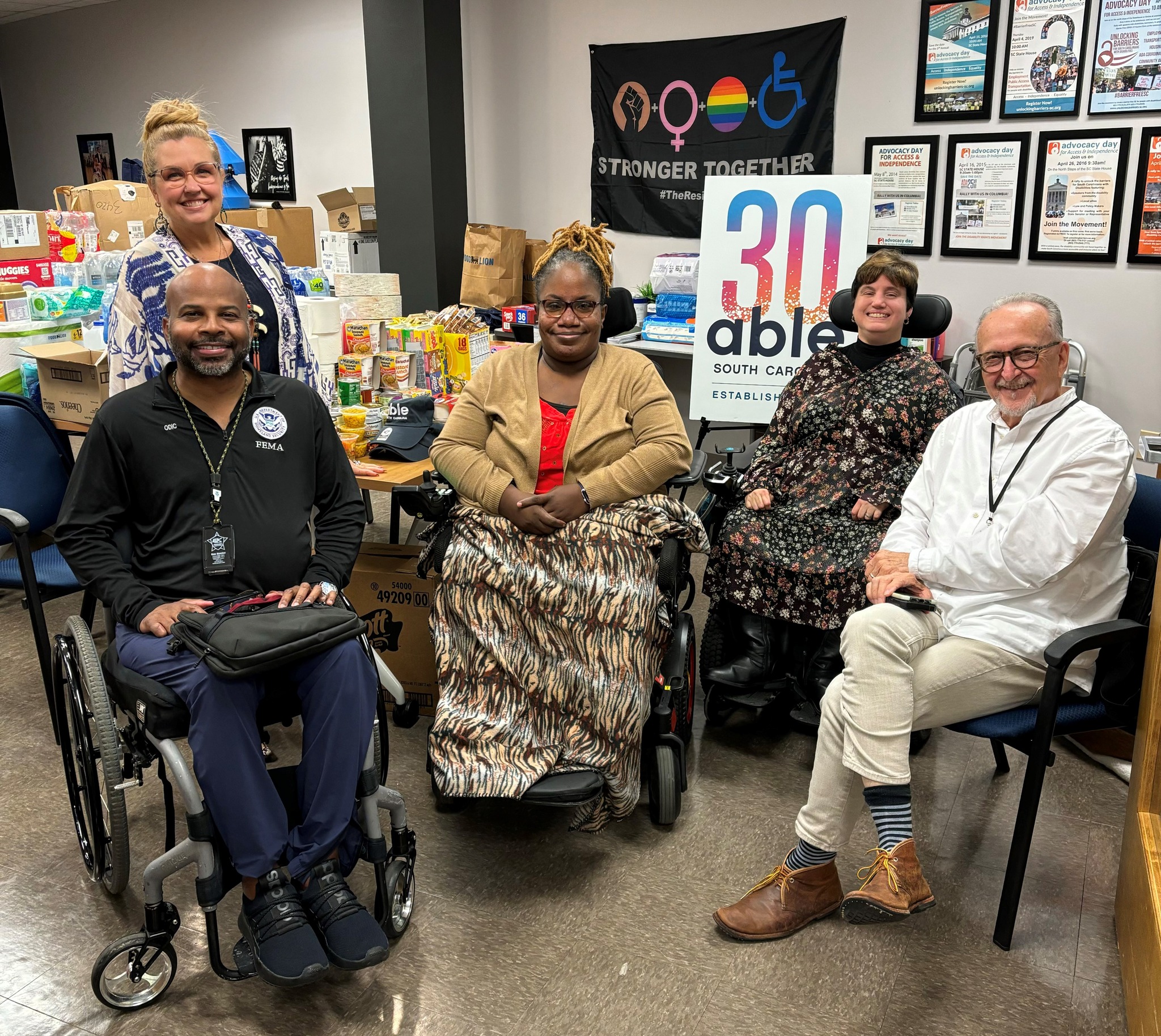 Director Gillums, Mandy Halloran, Able SC Director of Public Health and Disability Integration, Hope Jenkins, Administrative Assistant with Able SC, Dori Tempio, Able SC Senior Director of Community Education, and Everette Sedgewick, FEMA Disability Integration Advisor.[Able SC staff surrounded by hurricane relief donations, pose for a photo with the individuals listed in the post.