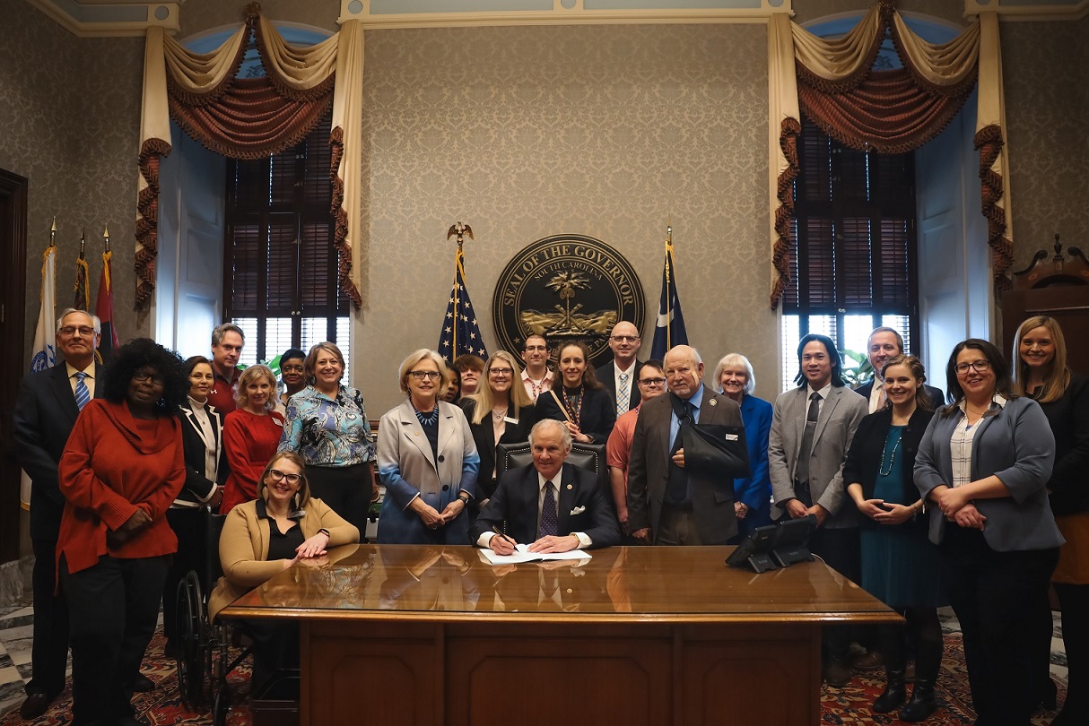 Governor McMaster surrounded by a group of people, signing bill s.533