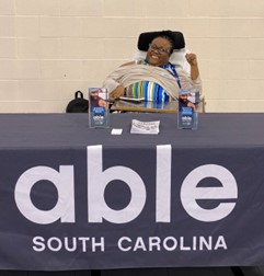 Able South Carolina’s Disability Health Equity Coordinator, Ebony Deloach, at the Northeast Columbia Empowerment Coalition’s third annual health fair. Ebony is a young, Black woman who uses a power-wheelchair for mobility.