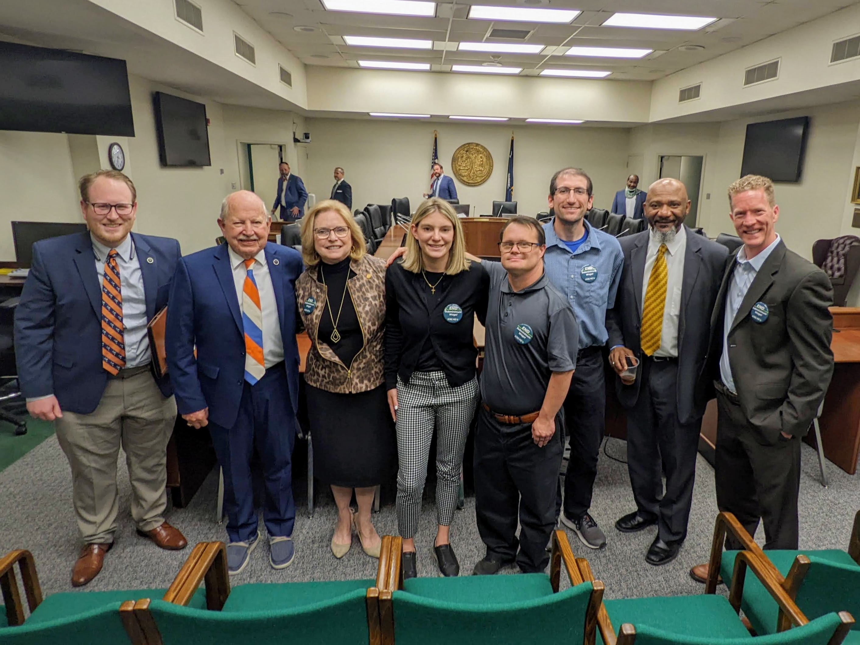 Group of sc represenatives and advocates with disabilities pose for a photo after subcommittee hearing inside the hearing room.